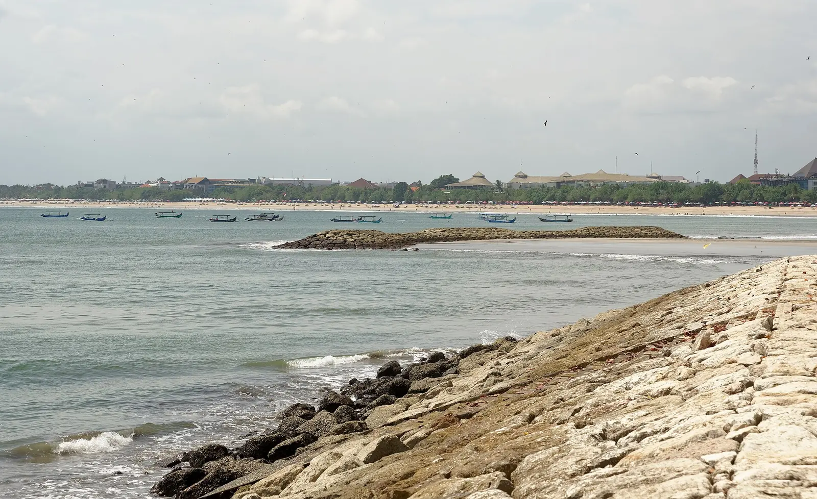 Is Bali veilig? Het strand bij Kuta op Bali met zonnebedden en surfers