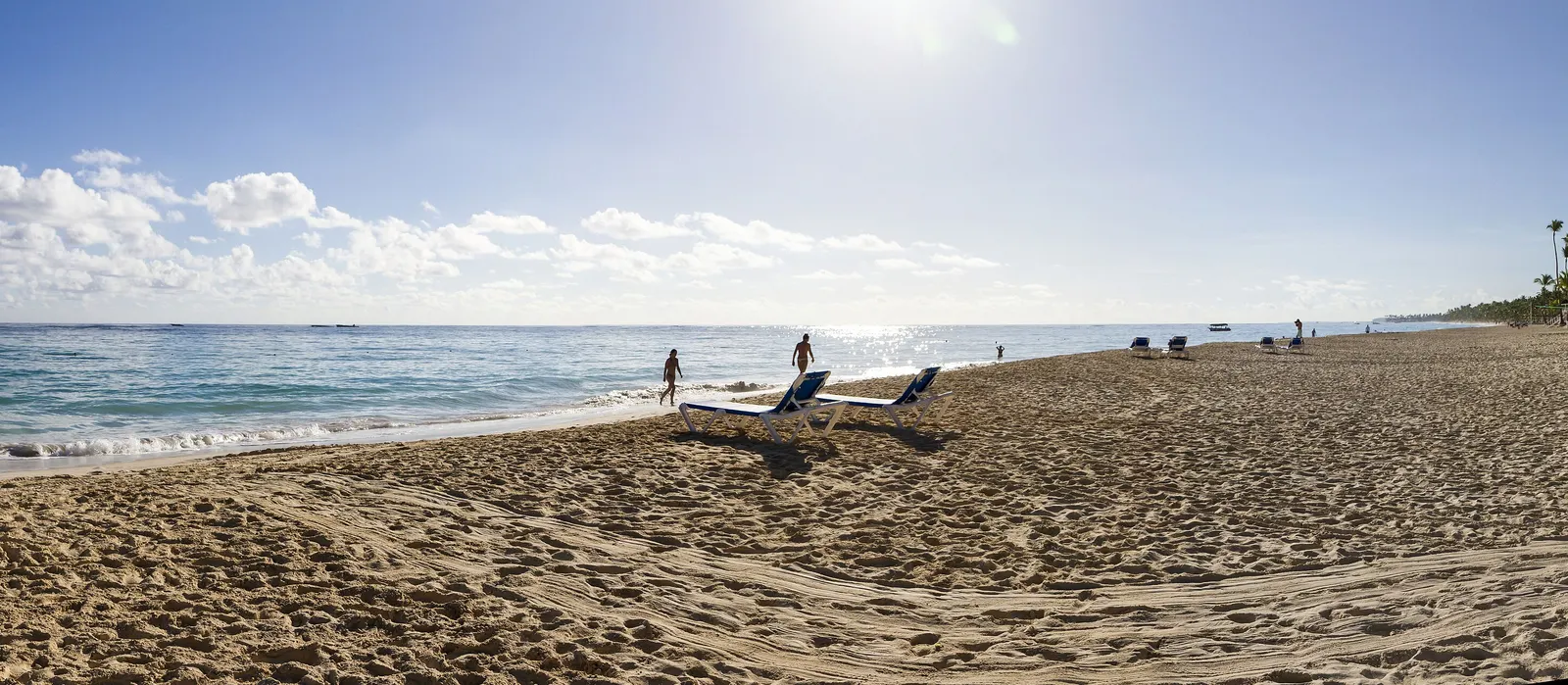 Is Punta Cana veilig? Het brede strand van Bávaro bij Punta Cana met ligbedden aan zee