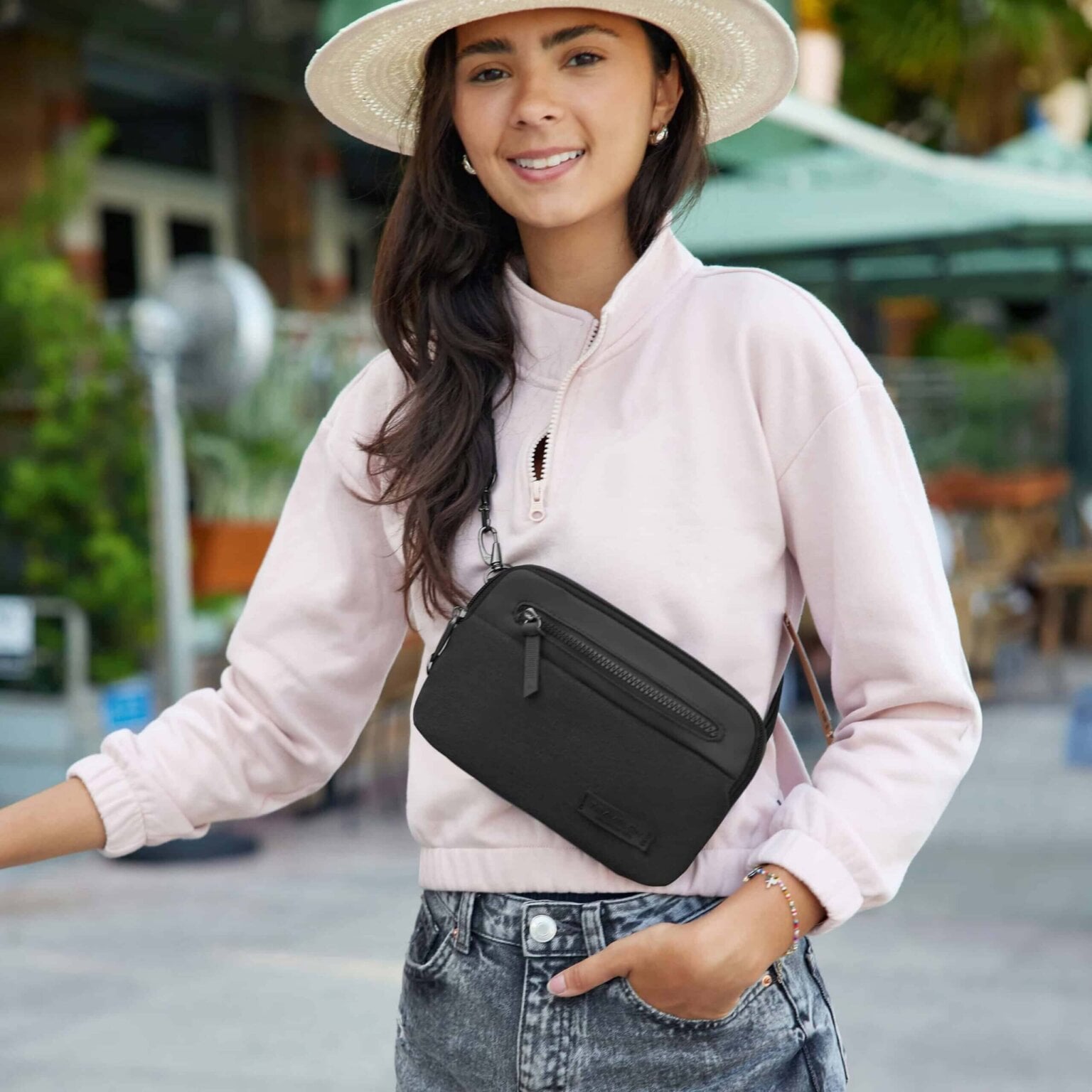Vrouw met de Travelon Metro Convertible Crossbody als heuptas gedragen