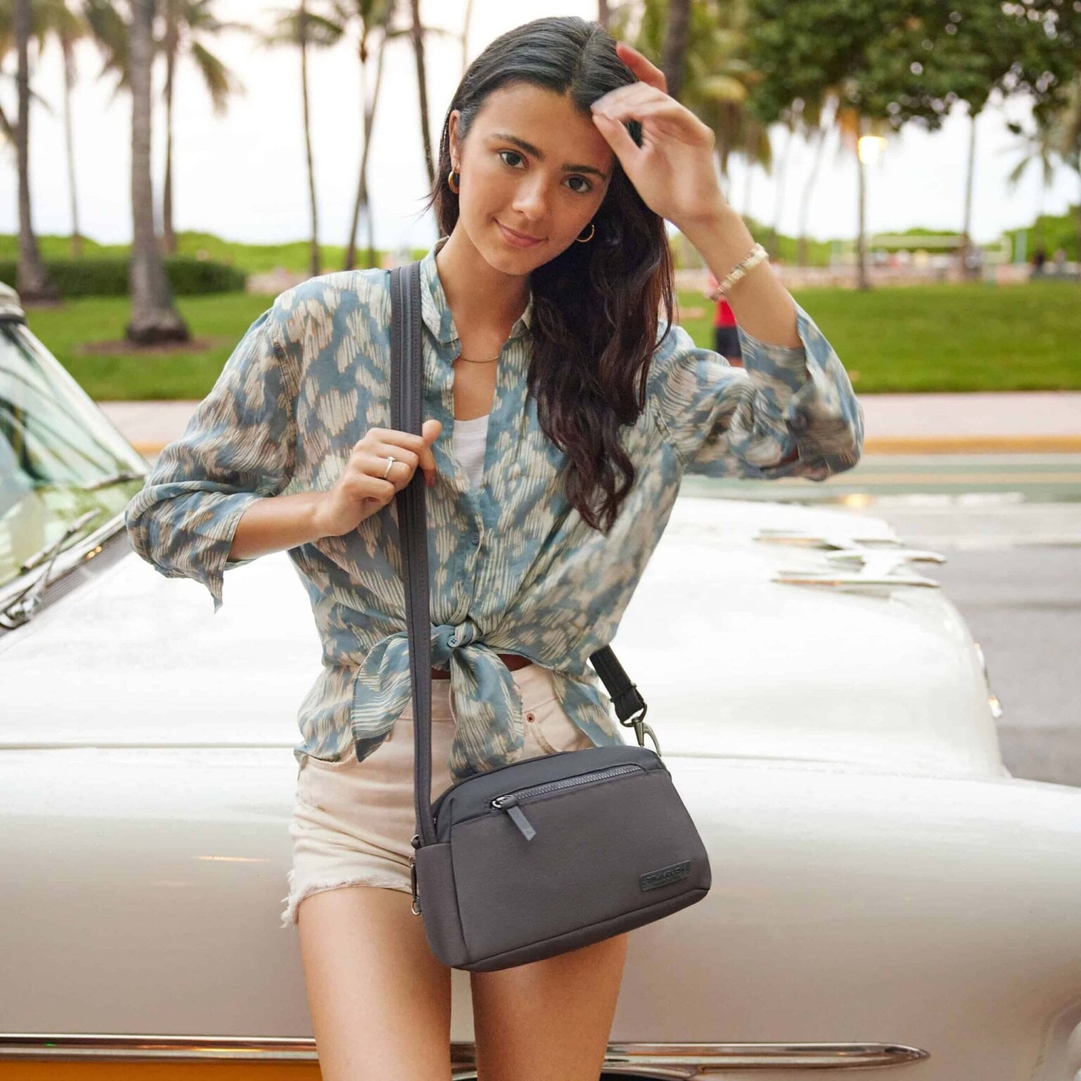 Vrouw met de Travelon Metro Dome Crossbody in grijs over haar schouder