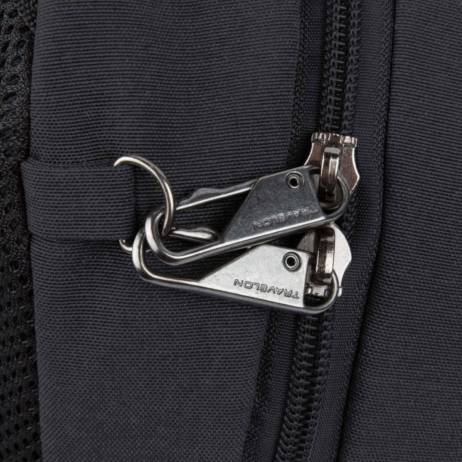 Vergrendelbare ritsen met karabijnhaak op de Travelon Metro Sling Bag
