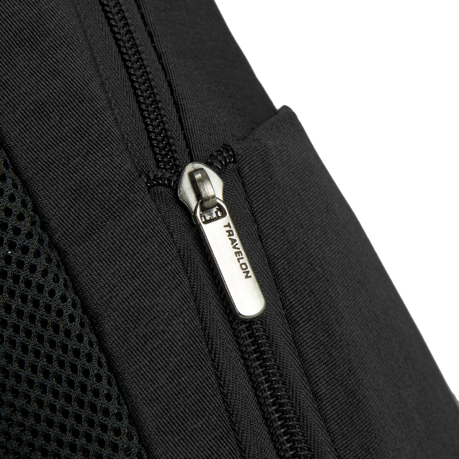 Detail van het mesh zijvak en de rits van de Travelon Metro Sling Bag