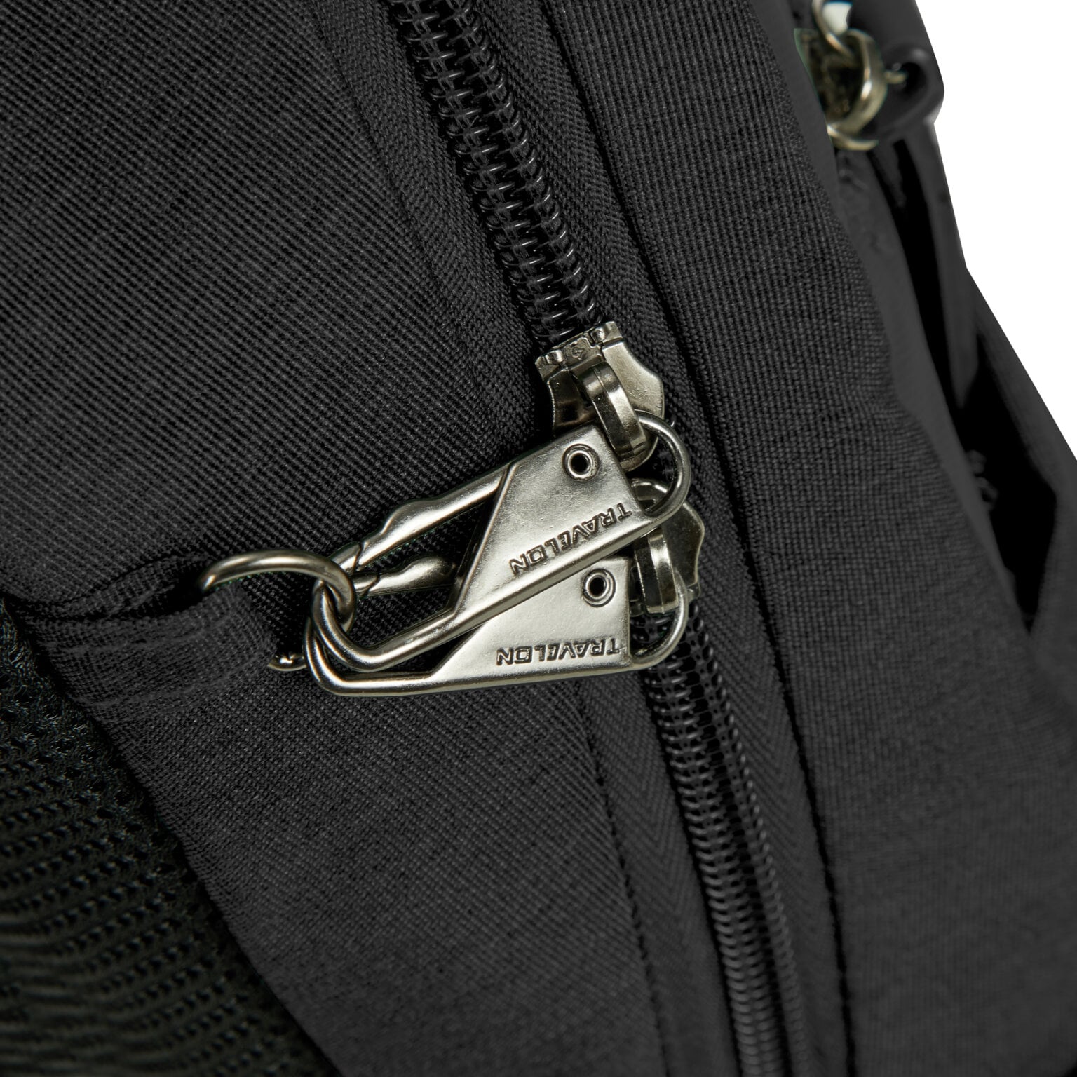Vergrendelbare ritsen met karabijnhaak op de Travelon Metro Sling Bag