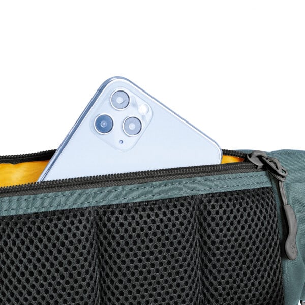 Telefoon in het mesh vak van de Travelon Voyages heuptas in blauw