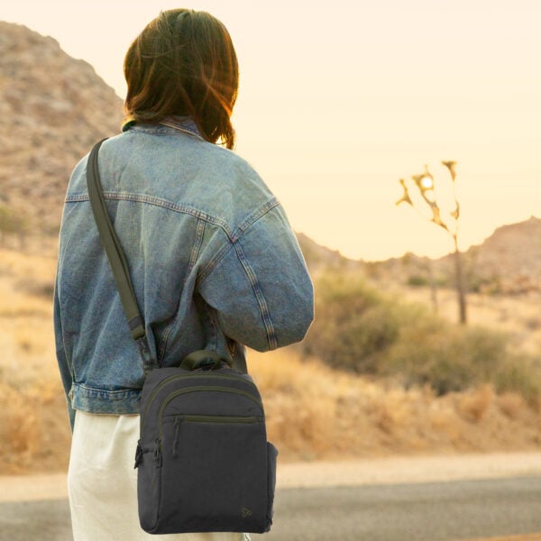 Vrouw draagt de Travelon Voyages tour bag in zwart crossbody in een woestijnlandschap