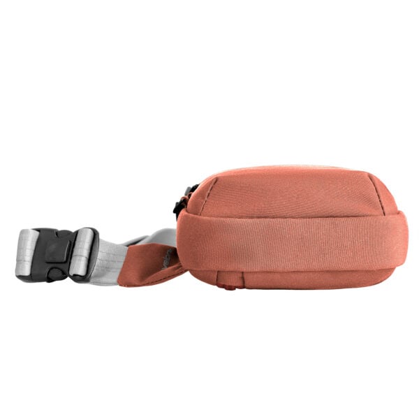 Travelon Voyages compact sling in koraal liggend met de band en klikgesp uitgerold