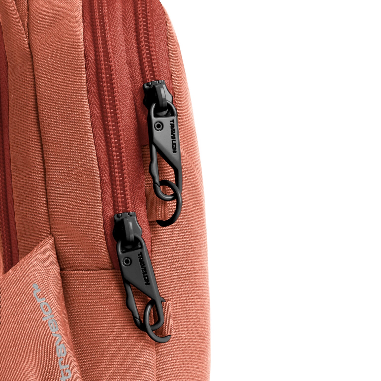 Detail van de twee vergrendelbare ritsen op de Travelon Voyages compact sling in koraal