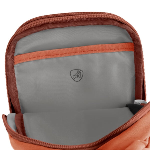 Geopend hoofdvak van de Travelon Voyages compact sling in koraal met RFID-beschermd vak