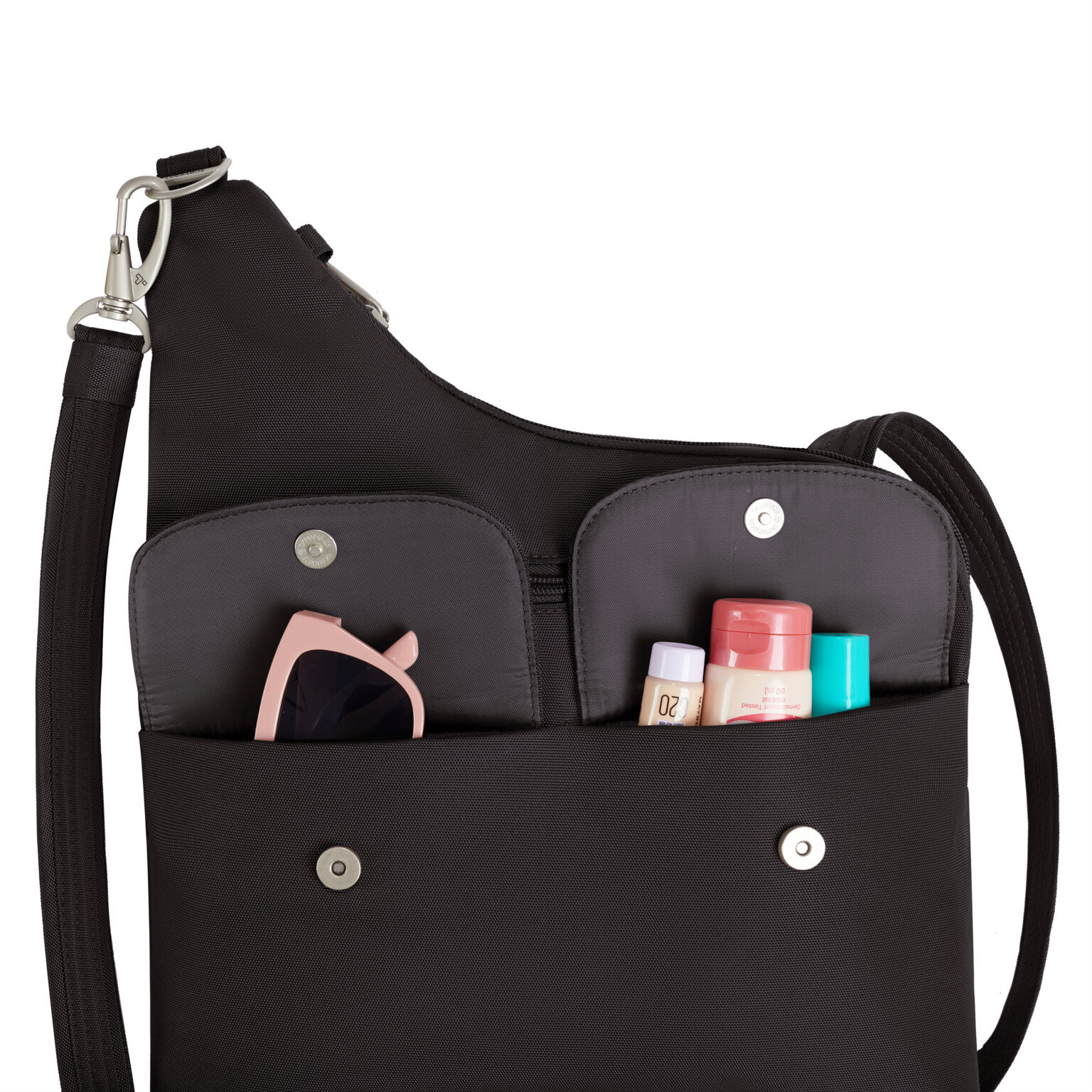 Voorvakken van de Travelon Classic grote crossbody tas in zwart met zonnebril en verzorgingsspullen