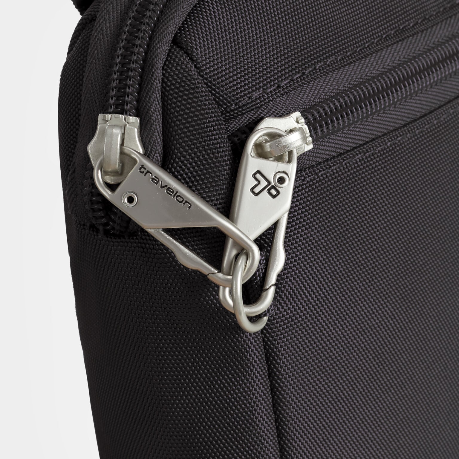 Vergrendelbare ritstrekkers van de Travelon Classic kleine crossbody of heuptas in zwart