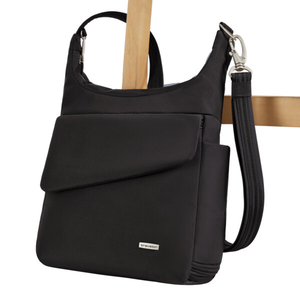 De Travelon Classic messenger tas in zwart vastgezet aan de poot van een stoel