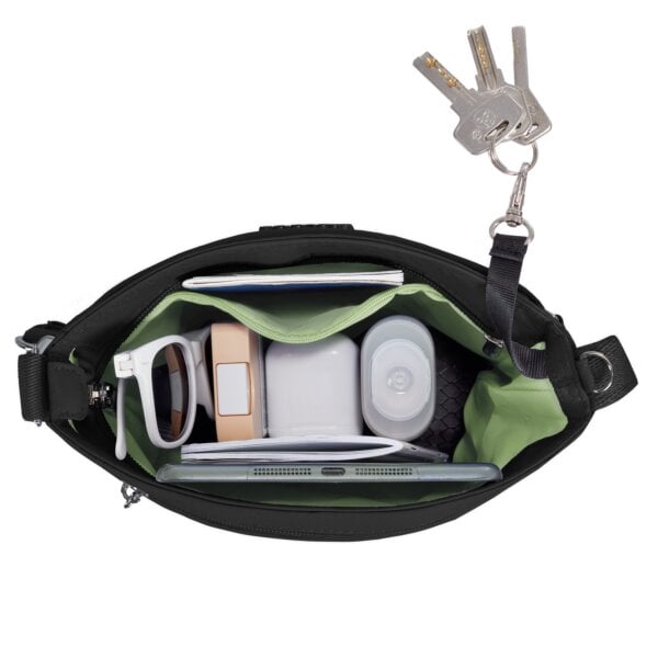 Hoofdvak van de Travelon Roam kleine crossbody tas in zwart met oortjes, oplader en telefoon